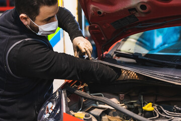 Wall Mural - mechanic repairing car. Mask. COVID19 Mechanical concept. Focus on the hands.