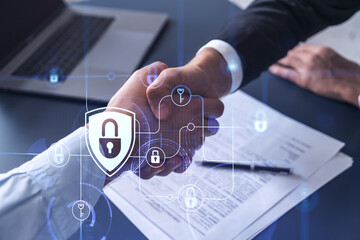 Handshake of two businessmen who enters into the contract to protect cyber security of international company. Padlock Hologram icons over the table with documents.