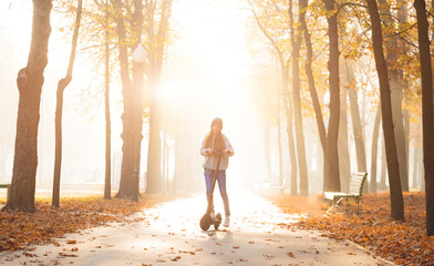 Wall Mural - girl on scooter in autumn park