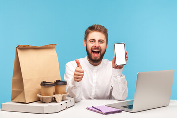 Wall Mural - happy satisfied male client showing thumbs up holding white screen smartphone, coffee pizza and pape