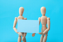 Wooden Mannequins With Blank Poster On Color Background