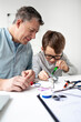 © epiximages - Father and son repairing an electrical outlet.