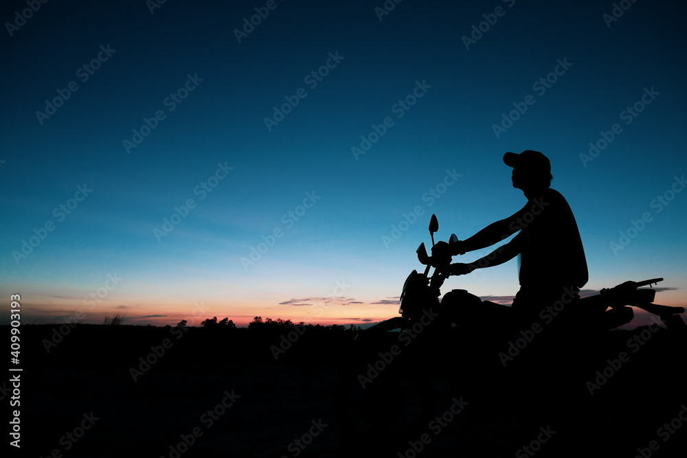Silhouette of a man wearing a hat with an Off-road motorbike In the evening - obrazy, fototapety, plakaty 