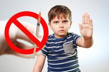 No Vaccination.  Little Boy Stops Hand Vaccination Against Covid-19.  Syringe Crossed Out With A Red Sign