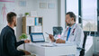 © Gorodenkoff - Friendly Family Medical Doctor is Explaining Diagnosis to a Young Male Patient and Showing Medical Test Results on a Laptop Computer in a Health Clinic. Bright Modern Hospital Office.