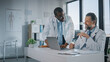 © Gorodenkoff - Young African American Physician is Talking to a Senior Doctor in a Medical Health Clinic. Colleagues Discuss Work on Laptop Computer in Hospital Office. Assistant Asks Medical Advice from a Doctor.