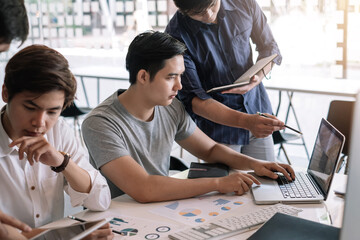 Wall Mural - Meeting of young asian business people who are committed to work. Creative business team sitting working together at office.