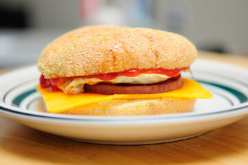 Wall Mural - fried eggs, a bun with cheese and sausage patty