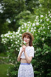© AKaltykova - a girl in a straw hat walks in a blooming garden