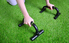 Fitness Training With Push Up Bars On The Artificial Grass