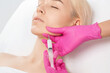 © Dimid - Cosmetologist makes lipolytic injections to burn fat on the chin, cheeks and neck of a woman against double chin. Female aesthetic cosmetology in a beauty salon.Cosmetology concept.