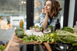 Young beautiful woman dreaming near healthy diet salad and green smoothie in the kitchen. Wellness and health care concept. High quality photo