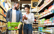 © Prostock-studio - African Family Buying Food In Supermarket Walking Choosing Groceries Together