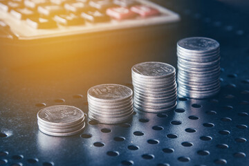 Stacks of money coin with calculator on black background, Business and Financial investment concept. 