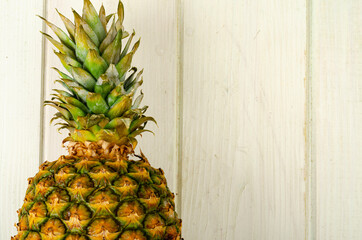 Exotic fruits. Ripe sweet ripe pineapple on wooden background. Studio Photo