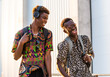 © Albert Morcillo/ADDICTIVE STOCK - Delighted African American male friends in stylish outfit enjoying stroll in city and laughing at joke together