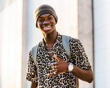 Content Handsome African American Male In Trendy Clothing Showing Thumb Up While Looking At Camera And Smiling