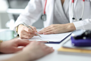 Wall Mural - Doctor advising patient and writing in documents closeup