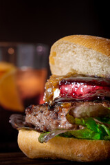 Sticker - Vertical shot of a tasty-looking burger near a beer glass on a dark background