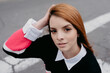 © Daniel Sierralta/ADDICTIVE STOCK - High angle of carefree female with red hair and in casual outfit standing in city street and looking at camera