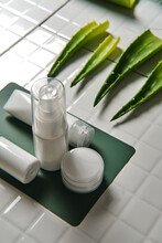Top View Of Green Aloe Vera Leaves Placed On Table With Various Cosmetic Products Showing Concept Of Natural Skin Care Treatment