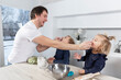 © Анна Демидова - A young dad is feeding small children in the kitchen. Fun time together.