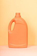 Bright plastic container from liquid detergent placed on vivid yellow background in studio
