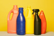 © Fernando Valencia/ADDICTIVE STOCK - Set of colorful assorted plastic containers from liquid detergents placed in row on yellow background in studio