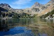 © German Linares/ADDICTIVE STOCK - Rocky mountains and blue sky reflecting in smooth surface of calm pond in highland area in Estany Gerber in Lleida, Spain
