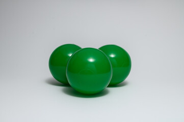 Wall Mural - Closeup of three green plastic balls isolated on a white background