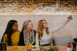 © Jake Jakab/ADDICTIVE STOCK - Group of cheerful diverse female friends sitting at table in cafe and taking selfie on smartphone while spending weekend together