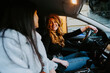 © Jake Jakab/ADDICTIVE STOCK - Cheerful female friends sitting on driver and passenger seat in contemporary car while talking and looking at each other