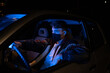 © Jordi Bataller/ADDICTIVE STOCK - Unrecognizable concentrated young male in casual clothes and face mask driving modern car with glowing neon lights at night during coronavirus