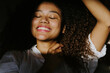 © Jake Jakab/ADDICTIVE STOCK - Young African American female with gorgeous long curly hair with eyes closed while sitting in sunlight