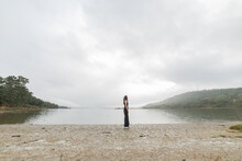 Wide Shot Of A Young Woman Enjoying A Lonely Beach On A Cloudy Day. Look Into Infinity
