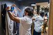 © Javier De La Torre/ADDICTIVE STOCK - Side view of Man trying on clothes in the clothing changing room of a clothing store