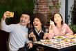 © Jose Carlos Cerdeno/ADDICTIVE STOCK - Group of positive young multiracial friends having fun and taking selfie on smartphone while enjoying delicious meal together in cozy cafe