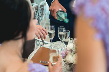 Wall Mural - People hold in hands glasses with white wine. wedding party.