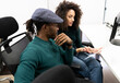 © Jose Carlos Cerdeno/ADDICTIVE STOCK - Positive young black African American woman and male colleague in casual clothing sitting at table and analyzing business results while working together in modern workplace