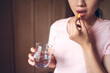 © Juan Alberto Ruiz/ADDICTIVE STOCK - Crop unrecognizable female with glass of fresh water taking yellow vitamin pill while representing healthy lifestyle concept