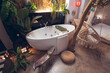 © Juan Alberto Ruiz/ADDICTIVE STOCK - Cozy hotel room with white bathtub and hanging rope chair near green tropical plants in traditional oriental style in Taiwan