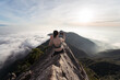 © Juan Alberto Ruiz/ADDICTIVE STOCK - Back view of female ethnic hiker sitting on top of Yuanzui Mountain and taking self portrait on smartphone
