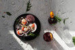 © Julianne Medeiros/ADDICTIVE STOCK - Top view of tasty oriental dish made of clams with herbs served on table with glasses of refreshing cocktails garnished with dried oranges