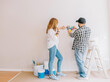 © Luis Baneres/ADDICTIVE STOCK - Back view of male worker and woman with paper palette picking color for walls during renovation process in apartment