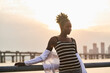 © Luis Gomez/ADDICTIVE STOCK - Tranquil pensive young African American female in casual clothes relaxing on urban seafront at sunset time