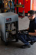 © Manuel Ruiz/ADDICTIVE STOCK - Adult man in goggles using laptop to program broken machine during work in modern workshop