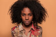© Manuel Ruiz/ADDICTIVE STOCK - Serious African American model with Afro hairstyle looking at camera on brown studio background