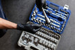 © Manuel Ruiz/ADDICTIVE STOCK - From above anonymous male technician in latex gloves selecting wrench bit from tool box during work in garage