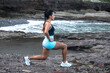 © Pablo Garcia/ADDICTIVE STOCK - Side view of young determined athletic female doing lunges during active training on rocky seashore while looking away