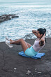 © Pablo Garcia/ADDICTIVE STOCK - High angle side view of determined sportswoman doing abs exercises while balancing on beach near sea during workout